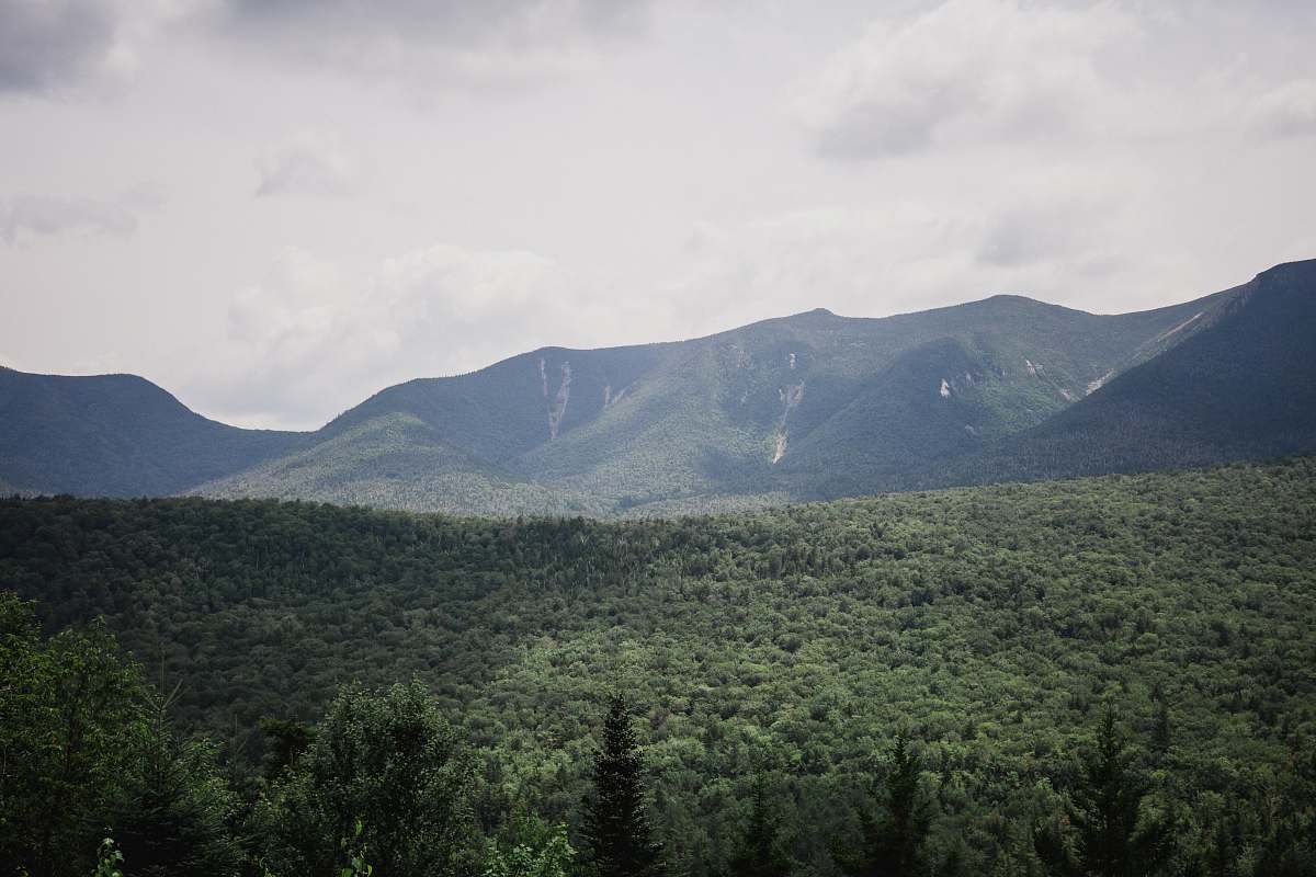 mountain range green and black mountains under white and gray sky at daytime kancamagus pass